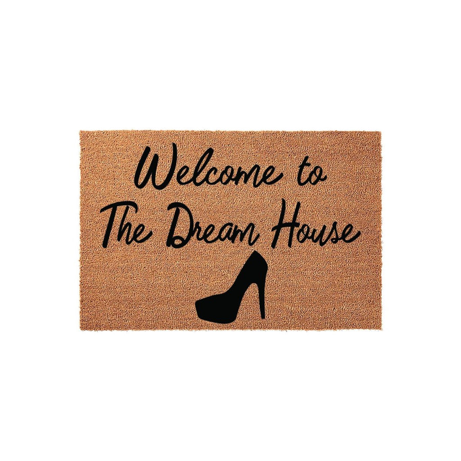 a textured area rug with the text "Welcome to The Dream House" printed on it, along with a silhouette of a high-heeled shoe.