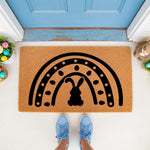 Easter bunny rainbow doormat featuring a black silhouette design on natural coir fiber, perfect for spring porch decor and front door entryways, creating a festive seasonal welcome mat for your home entrance during the holiday.