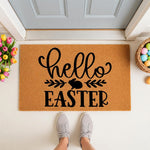 Hello Easter doormat with a cute bunny rabbit design, featuring natural coir fiber material for a spring front porch decor look, placed outside a front door with colorful tulips and a basket of eggs for a festive seasonal welcome