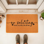 No soliciting doormat with funny dog theme, featuring black text and paw prints on a natural coir welcome mat, placed on a front porch to keep visitors away with a humorous message about dogs for home security and entryway decor.