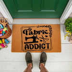 Fabric Addict sewing doormat for crafters, featuring a vintage sewing machine and scissors design on a natural coir welcome mat, perfect for a sewing room entrance or front porch decor for a quilting and sewing enthusiast.
