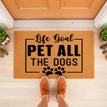 Funny dog lover doormat with Life Goal Pet All The Dogs text and paw prints, a natural coir welcome mat for front porch decor that makes a great gift for dog owners who want a stylish, durable, and humorous outdoor entrance rug.