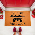 Video game Valentine doormat featuring a controller graphic and text on a natural fiber welcome mat, placed on a porch with red roses and gifts for a fun holiday home decor entrance that gamers will love for their front door.
