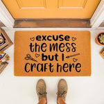 Craft room doormat with funny quote excuse the mess but I craft here, featuring scissors and paintbrush icons on a natural coir welcome mat.
