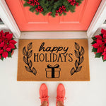 Happy Holidays coir doormat with a black gift box and leaf design, perfect for a festive front porch entry.