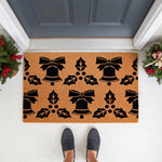 Christmas bell and holly doormat featuring a festive black pattern on natural coir fiber, perfect for a holiday front porch welcome mat.