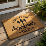 Farm Fresh Christmas Trees doormat with a rustic coir texture, featuring black printed text and pine tree icons for a festive holiday welcome mat design that adds farmhouse style to your front porch decor during the winter season.