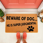 Funny dog doormat with the text Beware of Dog He Is Super Judgmental and a black paw print, featuring a natural coir fiber texture for a front porch welcome mat that makes a humorous housewarming gift for any pet owner.
