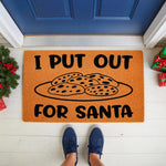 Funny Christmas doormat with a plate of cookies design and text reading I Put Out For Santa, this natural fiber welcome mat is a festive holiday porch decor piece for your front door entrance during the winter season.