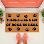 Funny dog lover doormat with paw prints and text reading There's Like A Lot Of Dogs In Here, a natural coir fiber welcome mat for pet owners placed on a front porch, perfect for dog house decor and humorous entryway floor mats.