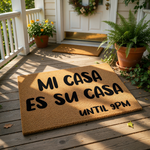 Funny doormat with the text Mi Casa Es Su Casa Until 9pm printed in bold black letters on a natural brown coir fiber welcome mat, perfect for a humorous front porch entrance or a unique housewarming home decor entryway accessory.