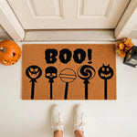 Boo Halloween doormat with spooky lollipop designs on a natural coir welcome mat, featuring a festive fall porch setting with a pumpkin and lantern for seasonal home decor, perfect for a fun autumn entryway and front door