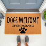 Dogs Welcome People Tolerated doormat featuring a funny quote and paw print design on natural coir fiber, perfect as a humorous front porch welcome mat for dog lovers and pet owners looking for a unique outdoor entryway floor rug.