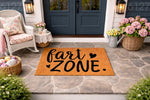 Fart Zone doormat featuring funny bathroom humor text on a natural coir welcome mat, displayed on a stone porch entry with a rocking chair and flowers, perfect for a humorous home decor entrance or a funny housewarming gift for