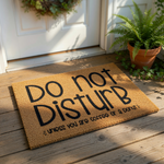 Funny Do Not Disturb doormat with coffee and donut text, a natural coir fiber welcome mat for front porch entryways that features bold black lettering for a humorous home decor statement piece for coffee lovers and donut fans.