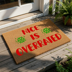 Funny Christmas doormat with the text Nice Is Overrated in red letters and green snowflakes on a natural coir fiber welcome mat, perfect for a humorous holiday front porch decor or a sarcastic winter entryway floor rug for your