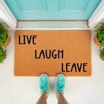 Funny Live Laugh Leave doormat made of natural coir fiber, featuring bold black text on a tan welcome mat placed at a teal front door, perfect for a humorous home entryway decor update that greets guests with a witty and