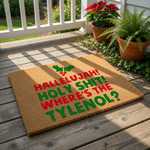 Funny Christmas doormat with red and green text reading Hallelujah Holy Shit Where's The Tylenol, featuring holly leaves on a natural coir fiber welcome mat for a humorous holiday porch decor entrance and festive home entryway.