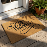 Funny Welcome Losers doormat made of natural coir fiber with a durable backing, featuring bold black script lettering that makes this sarcastic front porch mat a unique home decor piece for your entryway or housewarming entrance.