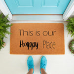 This is our Happy Place coir doormat for front porch decor, featuring a natural fiber welcome mat with black text placed on a white floor in front of a bright blue door, creating a stylish entryway look for your home or apartment.