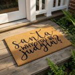 Funny Christmas doormat with the text Santa why you be judgin, a humorous holiday welcome mat made of natural coir fiber that makes a great festive front porch decor piece for your home during the winter holiday season.