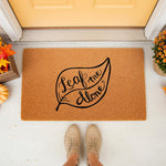 Leaf Me Alone fall doormat featuring a natural coir fiber texture and black script text, perfect for autumn porch decor, seasonal home entryways, and funny outdoor welcome mats for a cozy front door entrance during the harvest