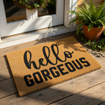 Hello Gorgeous doormat featuring bold black typography on a natural coir fiber mat, this stylish welcome mat serves as a decorative front porch rug or entryway floor mat for a modern home entrance with a fun and inviting message.