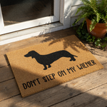 Dachshund doormat featuring a black silhouette of a wiener dog on natural coir fiber, with the funny text Don't Step On My Wiener printed below, making this a humorous outdoor welcome mat for any dog lover home entrance.
