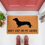 Dachshund doormat with funny wiener dog quote, a natural coir fiber welcome mat featuring a black dog silhouette and the text Don't Step On My Wiener, perfect for a humorous front porch entryway decor for dog lovers and pet