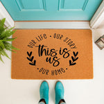 This is Us doormat featuring a natural coir fiber welcome mat with black text and leaf accents, perfect for a front porch entryway decor, housewarming gift, or personalized home entrance rug for a new house or apartment.