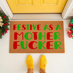 Funny Christmas doormat with festive red and green text on a natural coir welcome mat, placed on a porch with yellow shoes, holiday decor, and a bright yellow door for a rude, humorous, and seasonal home entrance decoration.