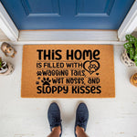 Dog lover welcome doormat featuring the text This home is filled with wagging tails, wet noses, and sloppy kisses, a natural coir fiber floor mat for pet owners that adds a cute decorative touch to your front porch entryway decor.