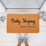 Baby Sleeping doormat with funny text for new parents, featuring a natural coir welcome mat on a porch with silver shoes and a plush toy, perfect for a nursery door or front entrance to keep visitors quiet and avoid waking the