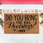 Funny doormat with the text Did You Bring The Bad Decisions printed in black on a natural coir fiber welcome mat, featuring a decorative script font and leaf accents for a humorous entryway decor piece for your front porch or