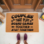 Couples board game doormat with funny quote, a natural coir welcome mat for front porch decor featuring dice icons and text about playing games together, perfect for a housewarming entry rug for gamers and couples who love