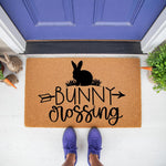 Bunny Crossing coir doormat for spring porch decor, featuring a black rabbit silhouette and arrow design on a natural fiber welcome mat, perfect for seasonal outdoor entryway floor mats and festive home entrance decorations.