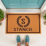 Personalized last name doormat featuring a black laurel wreath monogram design on a natural coir welcome mat, perfect for front porch decor and housewarming entryways to add a stylish touch to your home entrance and outdoor floor