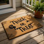 Trick or Treat Halloween doormat with a cute ghost and spider design on natural coir fiber, featuring spider web corner accents for a spooky front porch welcome mat that is perfect for fall home decor and seasonal entryway