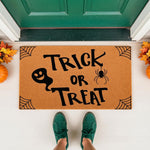 Trick or Treat Halloween doormat featuring a cute ghost and spider design on natural coir fiber, perfect for fall porch decor.