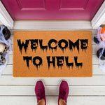 Welcome to Hell Halloween doormat with spooky dripping black text on a natural coir fiber rug, perfect for a scary front porch decor setup with skulls and cobwebs for a fun, creepy entryway entrance mat for your home this fall