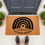 Rainbow welcome doormat with a black heart design on natural coir fiber, featuring the text Welcome To Our Home for a front porch entry, this durable outdoor welcome mat adds a stylish touch to any house entrance or apartment