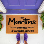 Personalized family name coir doormat with funny quote, featuring a natural fiber welcome mat on a porch in front of a purple door, perfect for housewarming decor or a custom entryway rug for a home with a humorous sense of style.