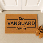 Personalized family name doormat featuring a custom last name in a black rectangular frame on a natural coir welcome mat, perfect for a front porch entrance, housewarming decor, or a stylish outdoor entryway floor rug for your