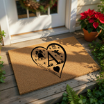 Personalized Christmas doormat featuring a large heart design with a central letter, holiday bell, and angel icon on natural coir fiber, making a festive front porch welcome mat for the winter holiday season and home decor.