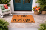 Be Kind Bring Wine doormat, a funny coir welcome mat for front porch decor, featuring bold black text on a natural fiber rug that adds a humorous touch to your home entryway, patio, or housewarming gift collection for wine lovers.