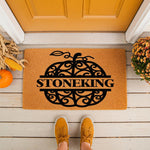 Personalized pumpkin doormat with a custom family name, featuring a decorative scrollwork pumpkin design on natural coir fiber.