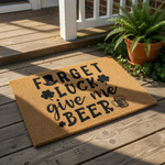 Funny holiday doormat with a natural coir texture featuring black text that reads Forget Luck Give Me Beer, decorated with shamrock icons, a leprechaun hat, and a beer mug graphic for a festive spring porch welcome mat decor.