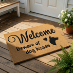 Dog lover welcome doormat featuring a silhouette of a Doberman Pinscher and the text Beware of dog kisses, this natural coir fiber welcome mat is a funny front porch rug for pet owners and a cute housewarming decor accessory.