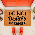Do Not Disturb I'm Gaming doormat for gamers, a funny coir welcome mat with a controller graphic placed on a porch, perfect for a bedroom door or front entrance to show your hobby with this unique, durable, and humorous floor rug.