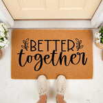 Better Together doormat featuring black script text on a natural coir fiber welcome mat, perfect for a front porch entryway, housewarming gift, or wedding decor, shown with casual sneakers standing on the rug in a bright home